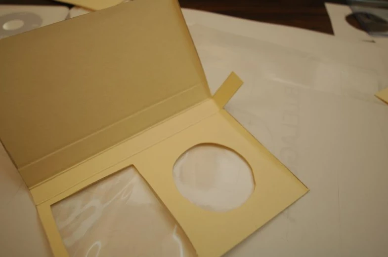 some cardboard that is holding a disk and some dvd