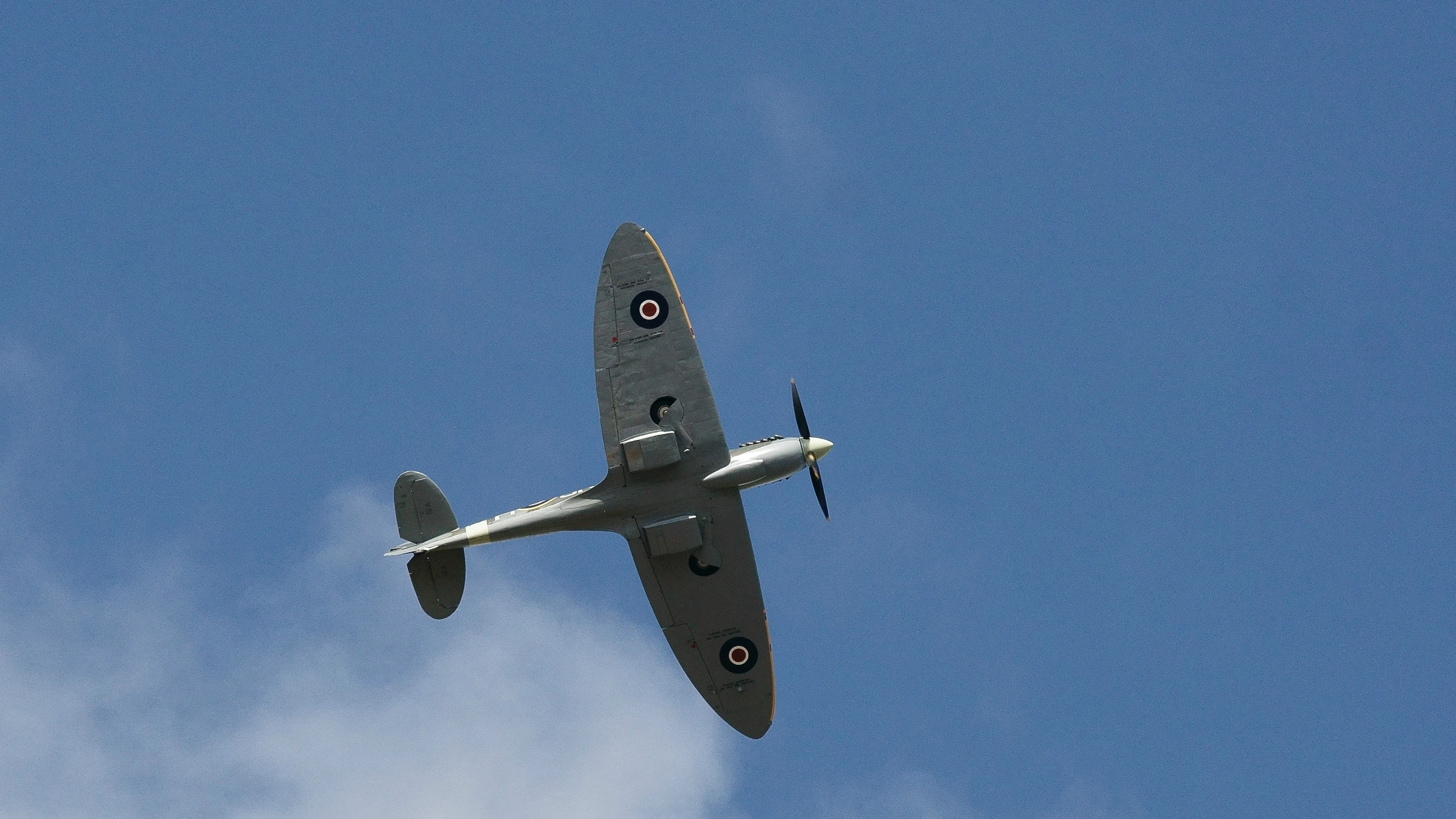 an old airplane flying through a blue sky