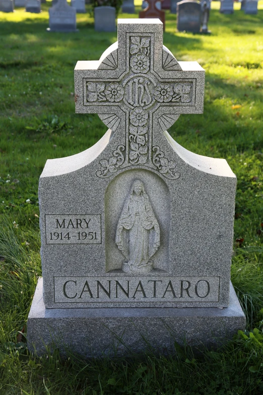 a large gray cross sitting on top of a cement grave