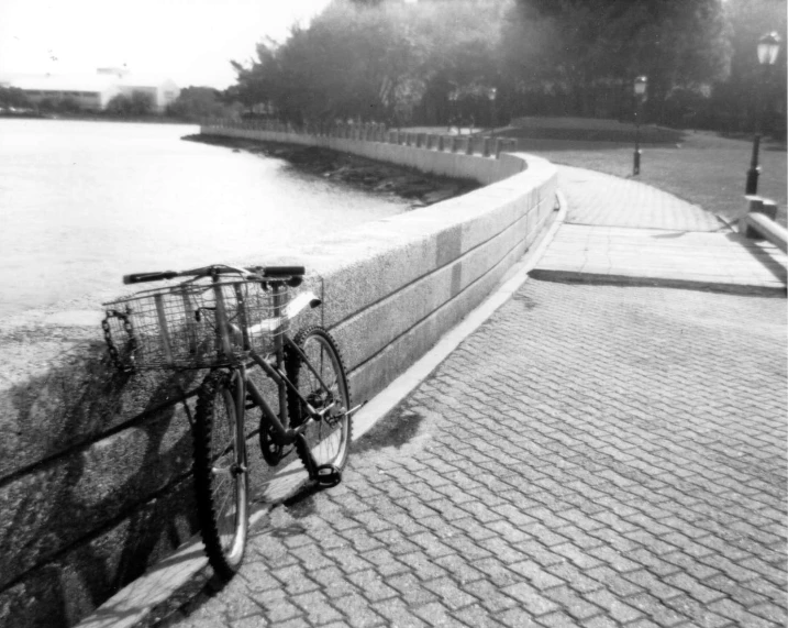 black and white image of bicycle leaning on a wall