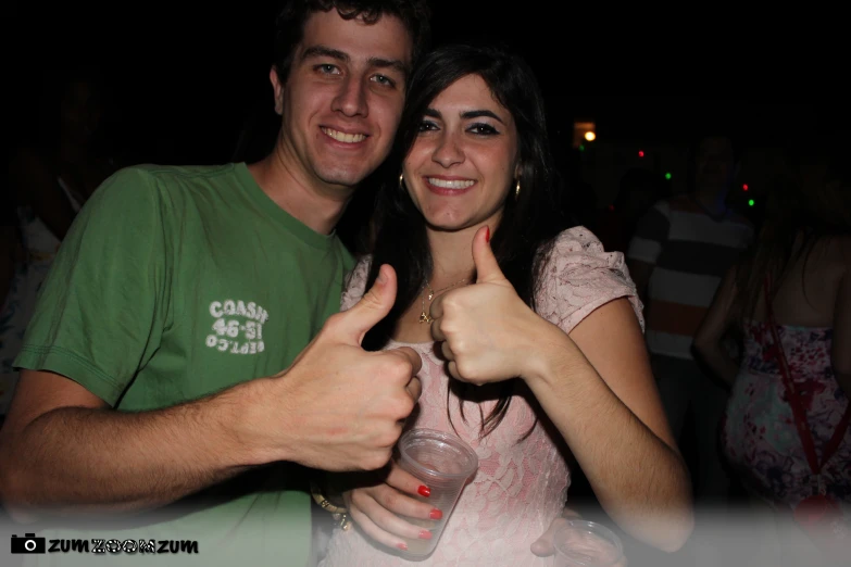 two people giving the thumbs up sign