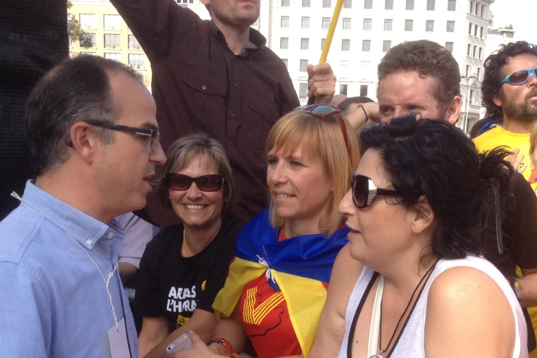 a woman is talking to two other people at a rally