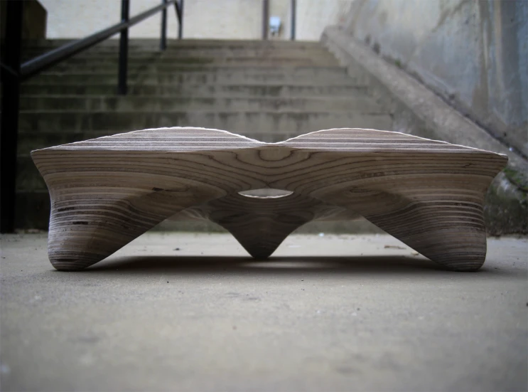 a wooden bench sits on the ground near stairs