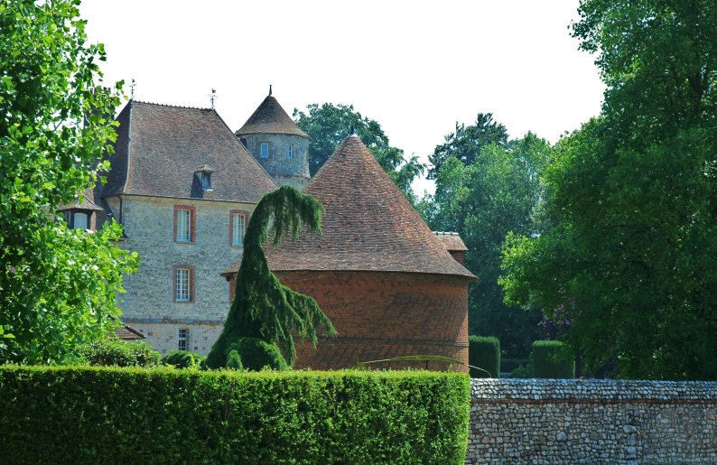 a large brick castle surrounded by lush green trees