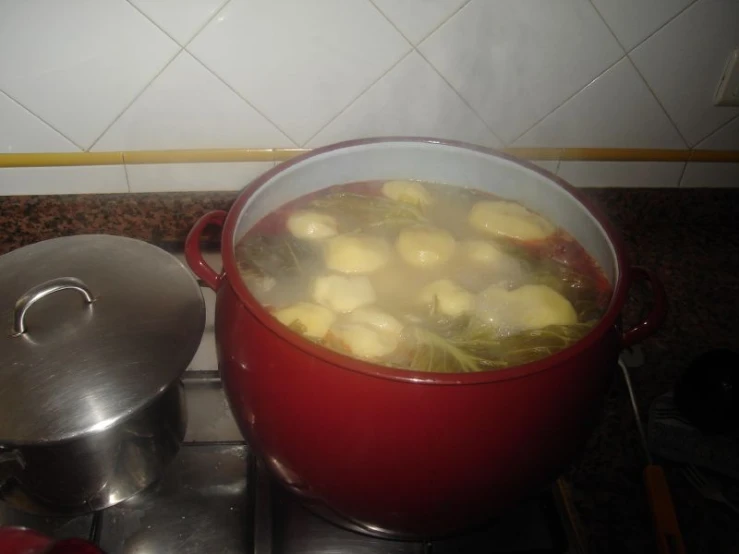 a pot on the stove next to a large pot filled with food