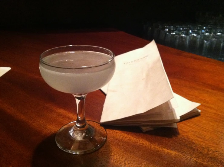 an alcoholic cocktail served in a glass on a table