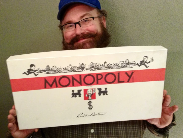 a man holding up a monopoly sign with the words monopoly