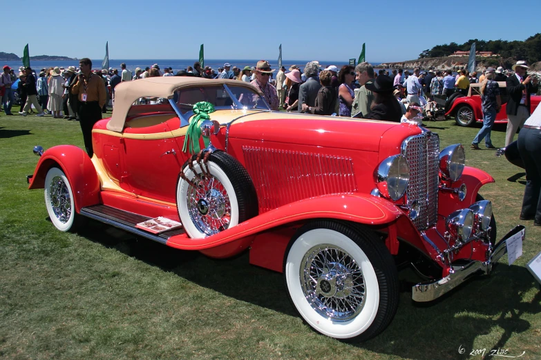 red vintage car with the bonnet off, at a convention