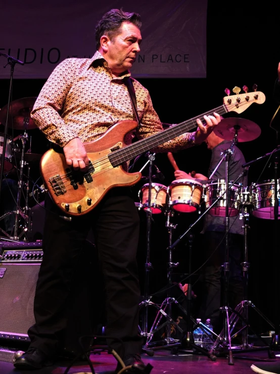 a man plays a bass guitar on stage