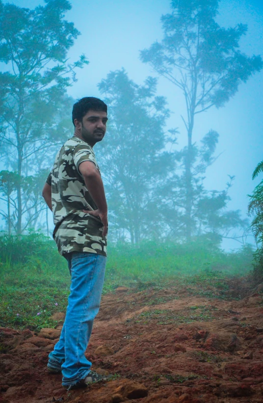 a man standing in a field next to trees