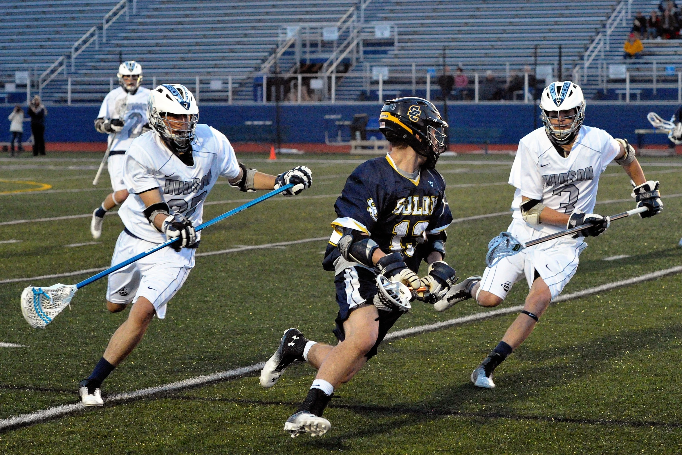 several lacrosse players are playing on the field