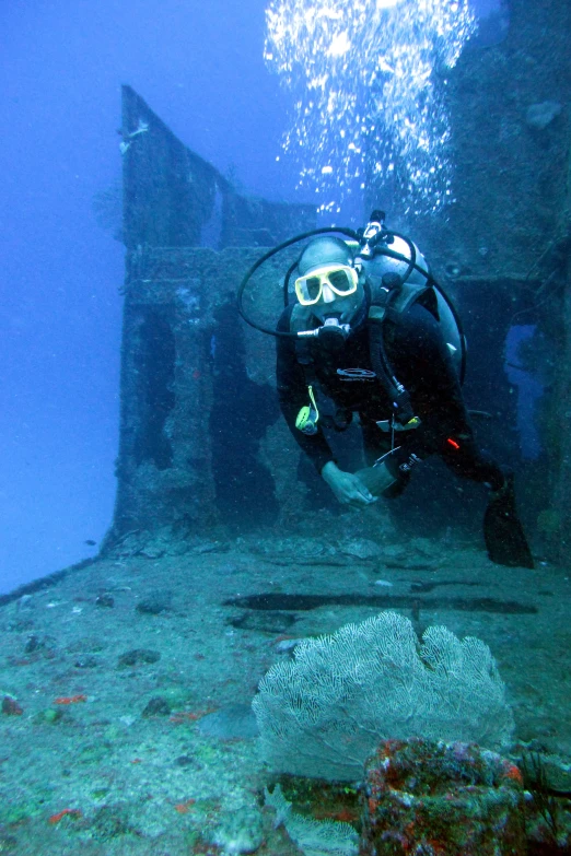 a person is diving in the ocean, with the boat sunk