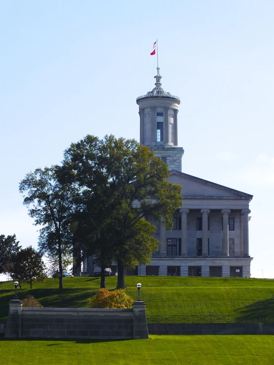 the clock tower on the side of the old building with a flagpole