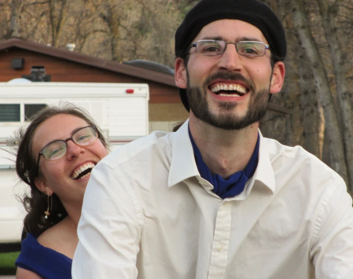 a smiling man sitting next to a smiling woman