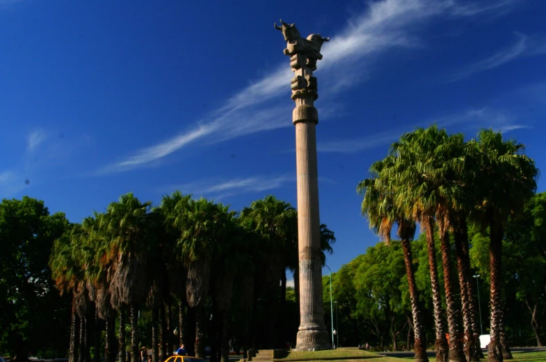 a tall statue is in front of some palm trees