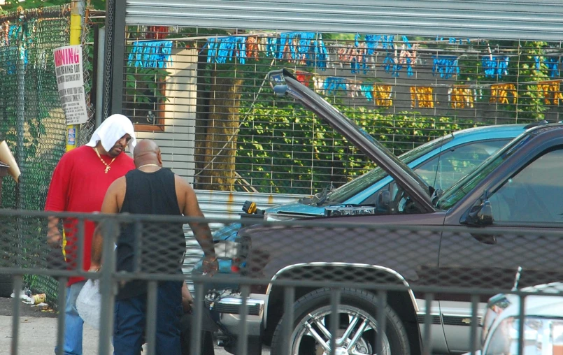 a couple is walking past an odd looking car