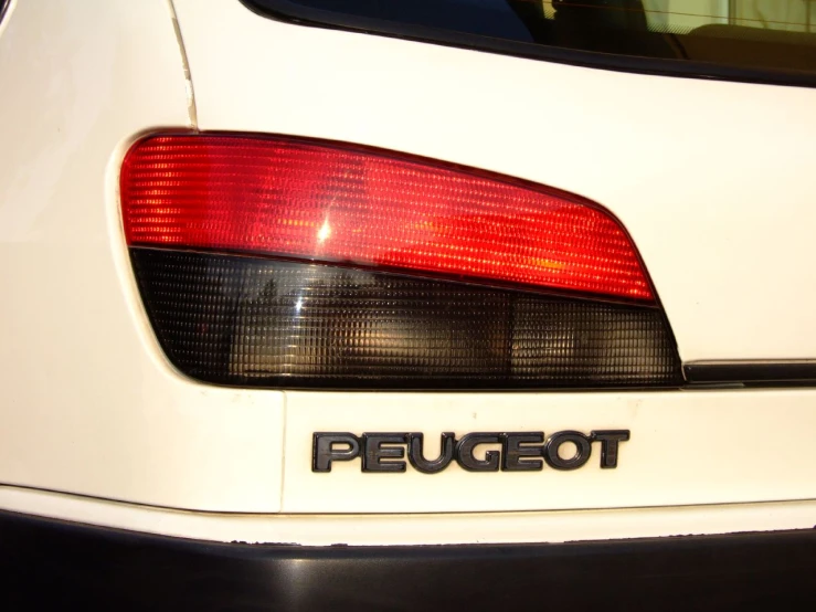 a white mustang sits parked with its tail lights on