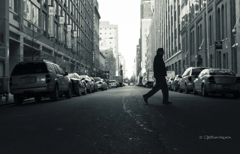 black and white image of a man walking on street