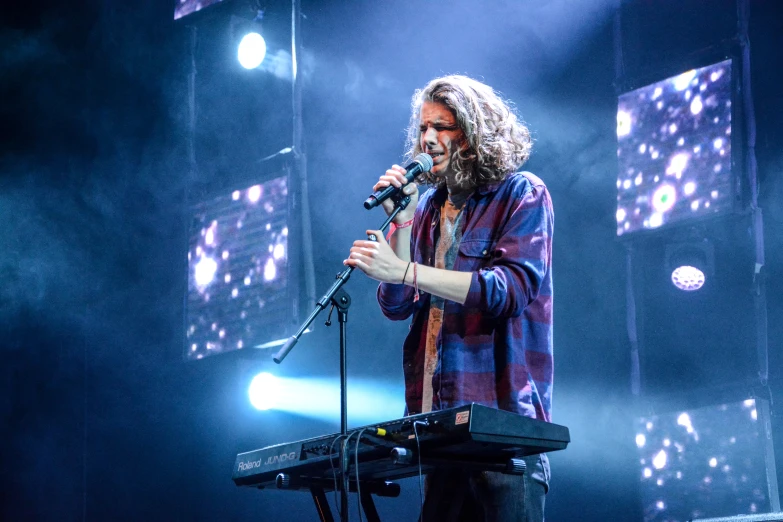 a man standing next to a microphone on top of a stage