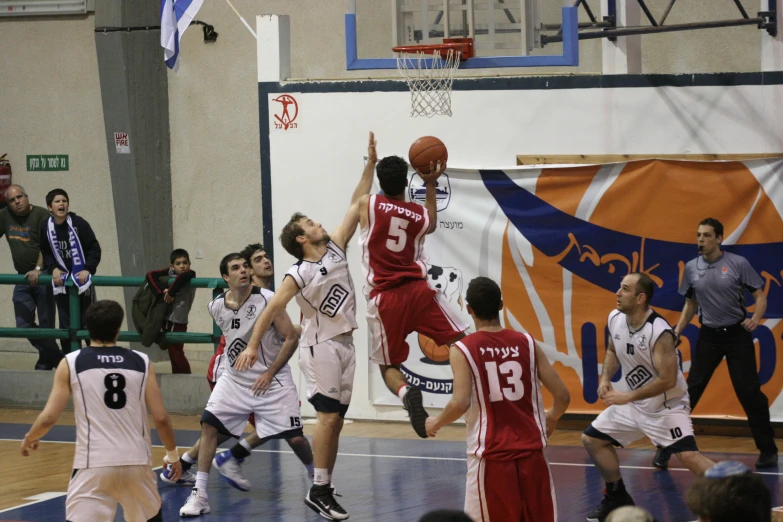 a bunch of men playing basketball inside a court