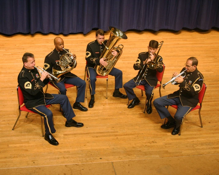 a group of four men in uniform play trombones