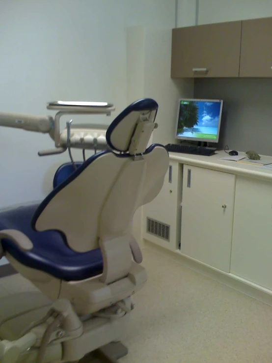 this is an office with a computer screen and dental chairs