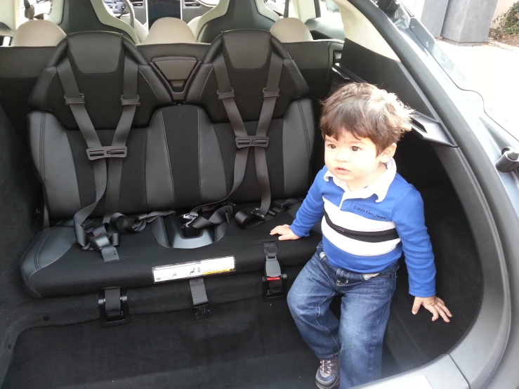 a baby boy in car seat next to cars seats