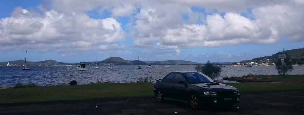 a small black car is parked on a pathway