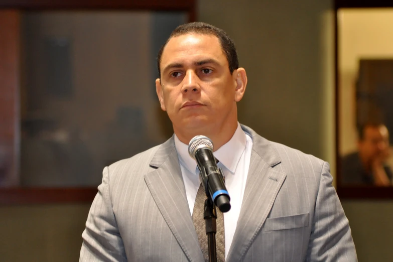 a man in a suit standing at a microphone