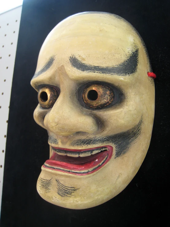 an odd looking mask with large eyes on display