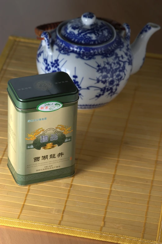 a can and teapot sit on a bamboo mat