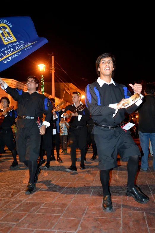 a man holding a blue and white flag and dancing