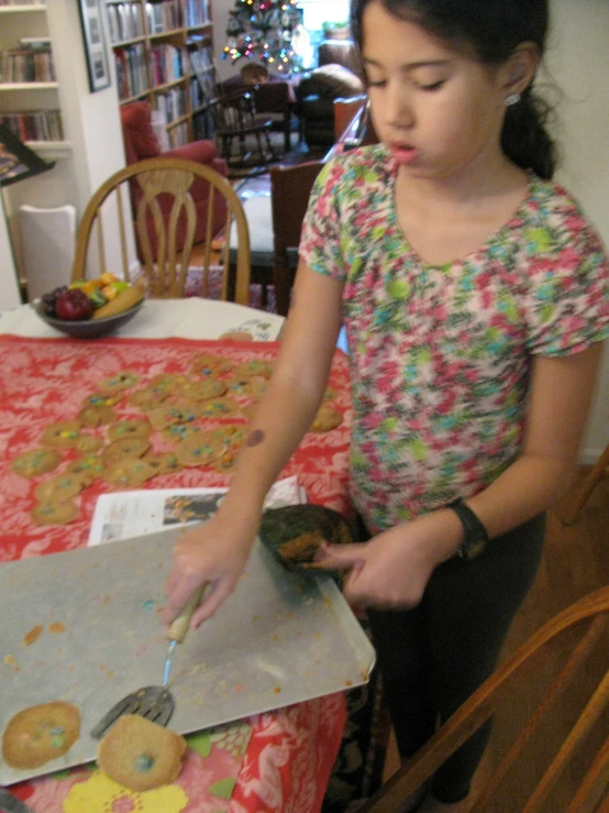 a  standing over a cookie on a table