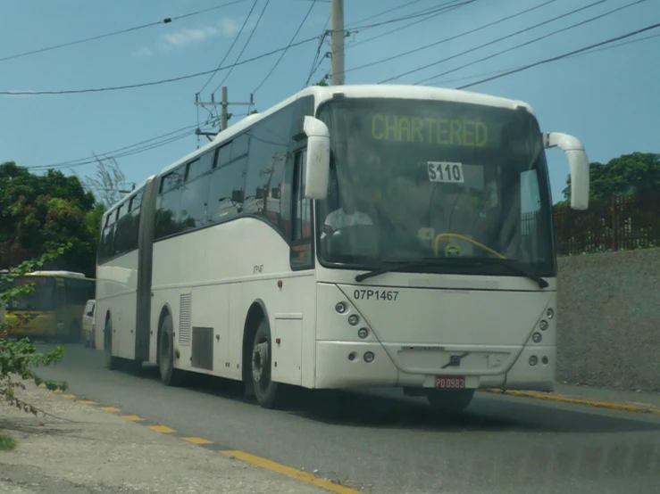 a long bus driving down a road