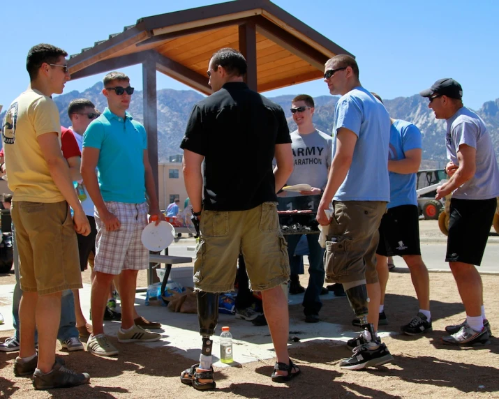 several people are talking in front of a bbq