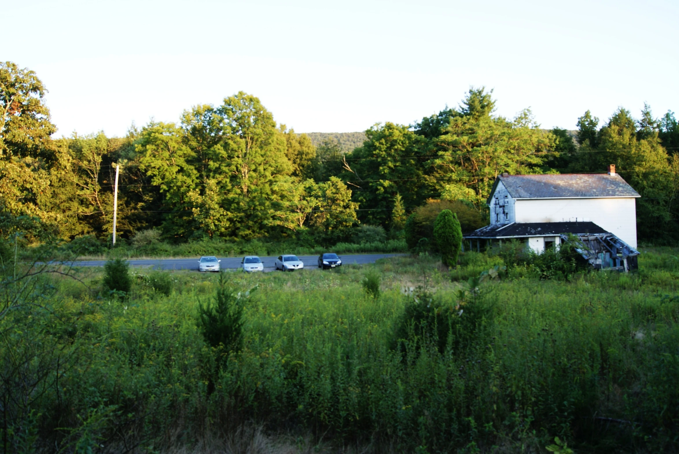 some houses and cars driving in the middle of a field