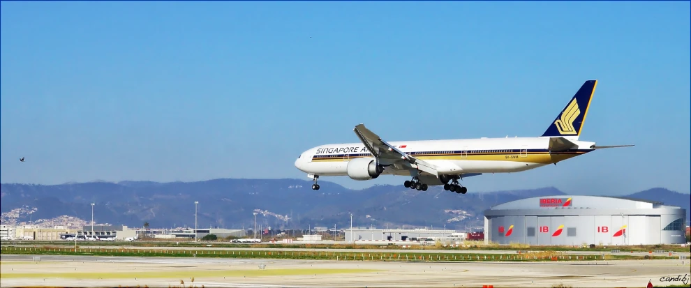 a large jetliner flying over an airport runway