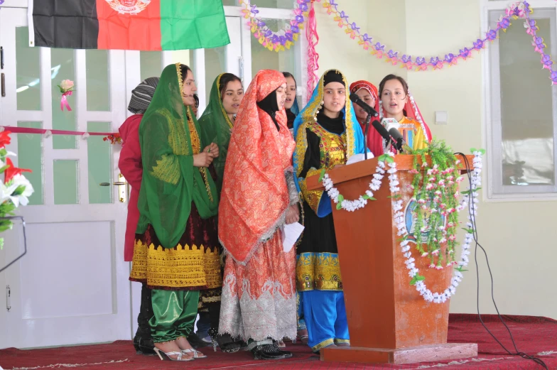 some people wearing bright colorful clothes are standing at a podium