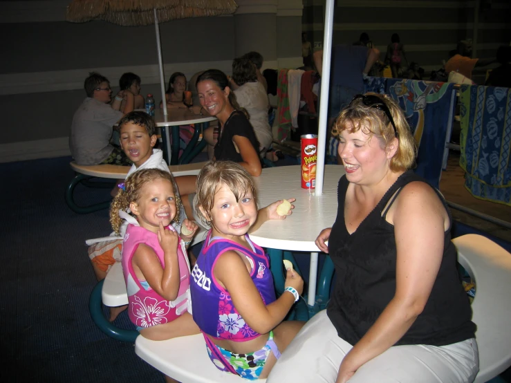 five girls in bathing suits eating at a restaurant