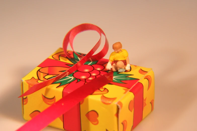 a small gift wrapped in yellow and red