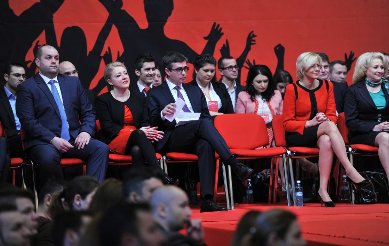 several people sitting in front of two men and one woman