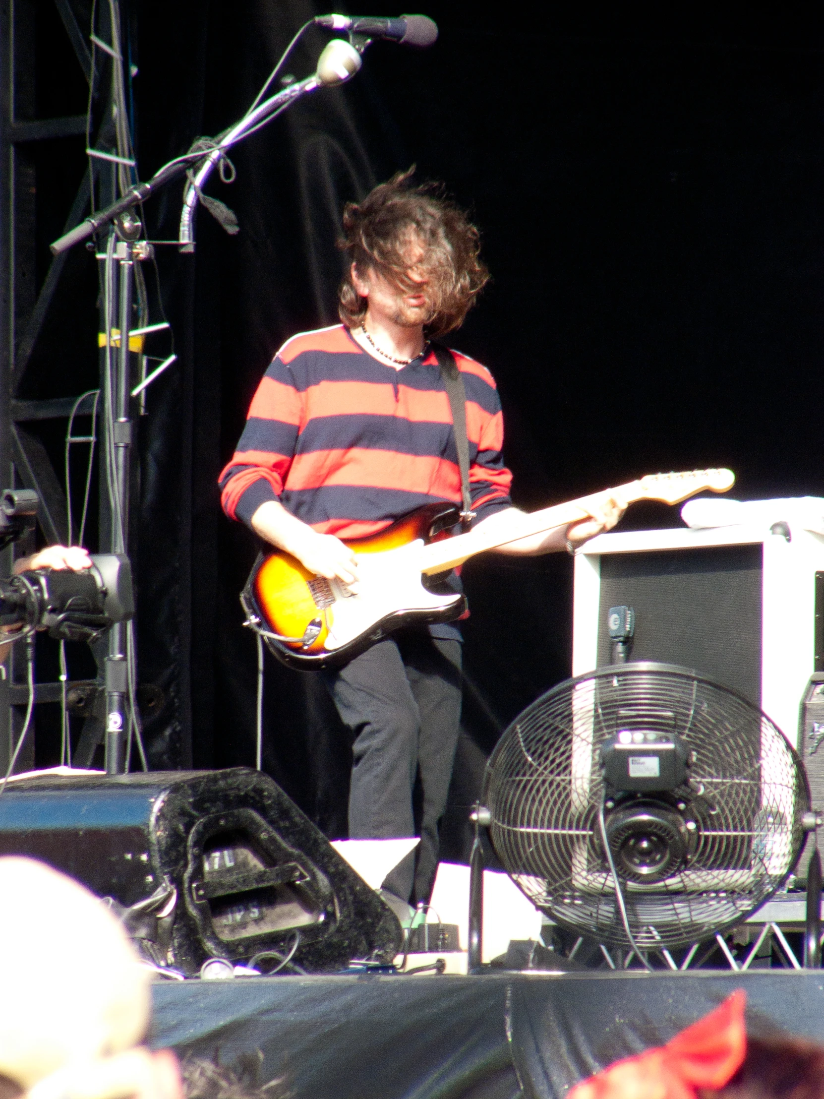 a man playing the guitar while standing on a stage