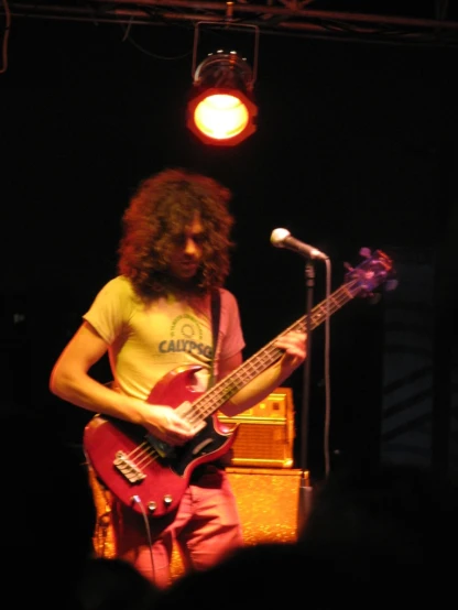 a musician with long hair playing a bass guitar