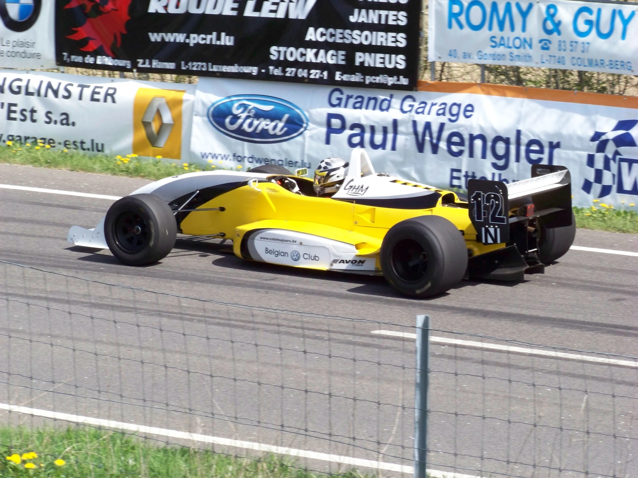 a man driving a race car down a street