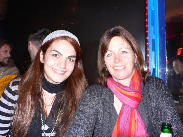 two women with hats and scarves pose for a picture