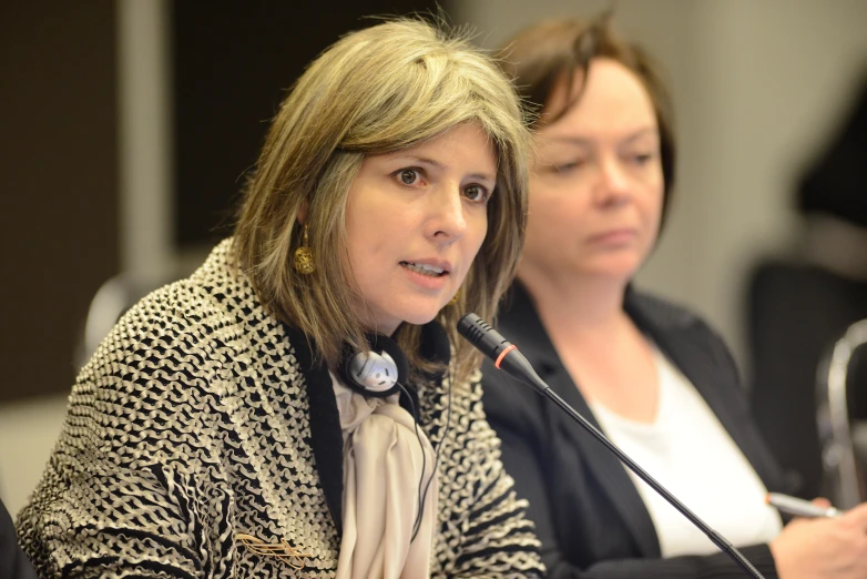 a woman giving a presentation while holding a microphone