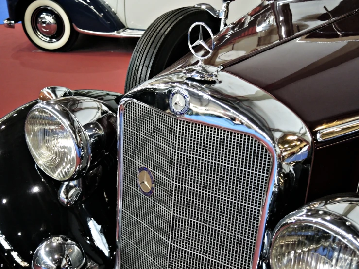 two antique style cars that are parked inside of a building