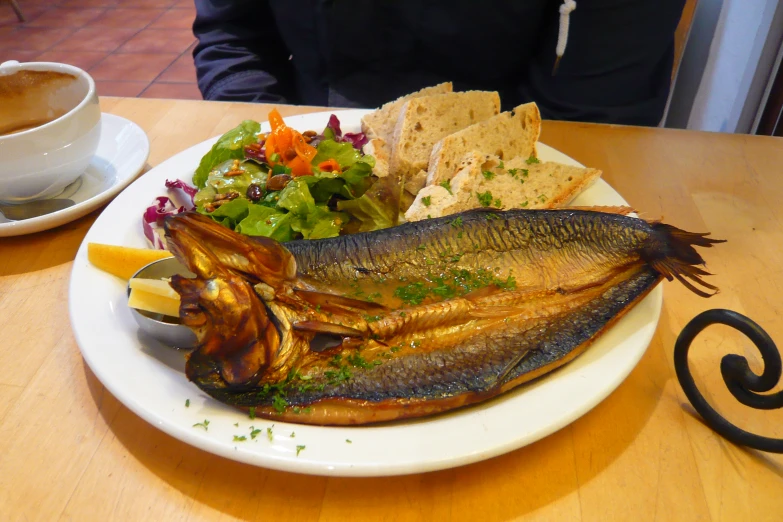 fish, ers and a salad served on a white plate