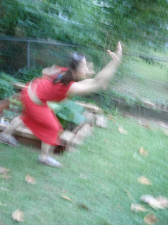 a woman in a red dress throwing a frisbee