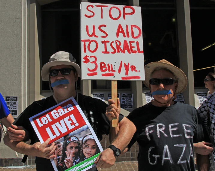 a group of protesters gathered outside a business for a campaign